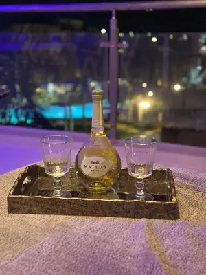 a bottle of wine and two glasses on a tray at Modern Penthouse Overlooking Pool in Pyla