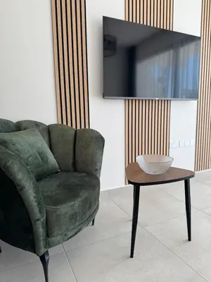 a living room with a green chair and a table at Modern Seaside Studio at Northern Cyprus - Pearl Island in Pyla