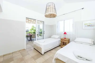 a bedroom with two beds and a dining room at Villa Marilena in Protaras
