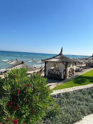 a beach with some umbrellas and the ocean at Apartman Severny Cyprus in Iskele