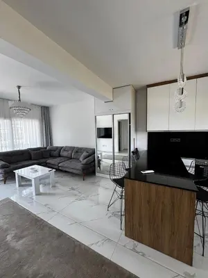 a kitchen and living room with a couch and a table at Apartman Severny Cyprus in Iskele