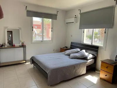 a bedroom with a bed and two windows at Sunflower Oroklini in Voroklini