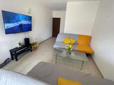 a living room with a couch and a tv at Sunflower Oroklini in Voroklini