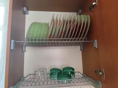 a shelf with glass bowls and plates on it at Julia Holiday Apartment in Larnaka