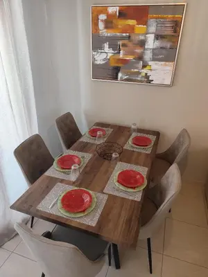 a wooden table with four red plates on it at Julia Holiday Apartment in Larnaka