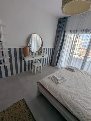 a bedroom with a bed and a mirror and a chair at Caesar Blue Studio Sea View Apartment in Boğaz