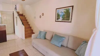 a living room with a couch with blue pillows at STAY Sea Gem Apartment in Meneou