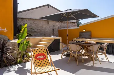 a patio with a table and chairs and an umbrella at Exquisite 2BR modern village house w private pool in Ayios Tykhonas