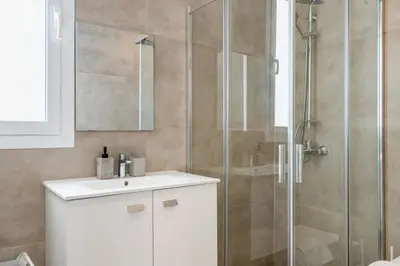 a bathroom with a shower and a white sink at Blu Horizon - Stylish Living with Pool & Balconies in Protaras in Paralimni