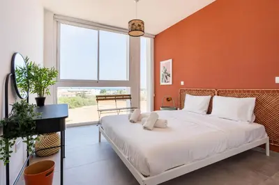 a bedroom with a large bed with orange walls at Blu Horizon - Stylish Living with Pool & Balconies in Protaras in Paralimni
