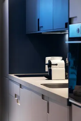 a kitchen counter with a sink and blue cabinets at Aweso Limassol in Limassol