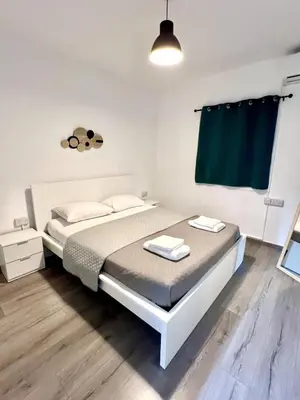 a bedroom with a bed and a green curtain at Fully Equipped One Bedroom APT in Limassol