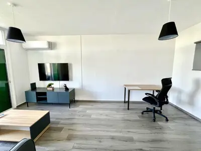 an office with a table and chairs and a tv at Fully Equipped One Bedroom APT in Limassol