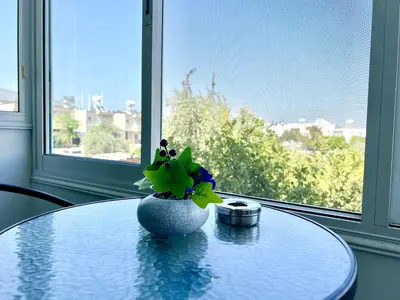 a table with a vase with flowers on top of it at Fully Equipped One Bedroom APT in Limassol