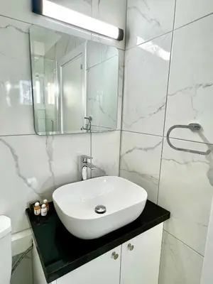 a bathroom with a white sink and a mirror at Fully Equipped One Bedroom APT in Limassol