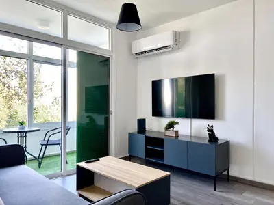 a living room with a couch and a tv and a table at Fully Equipped One Bedroom APT in Limassol