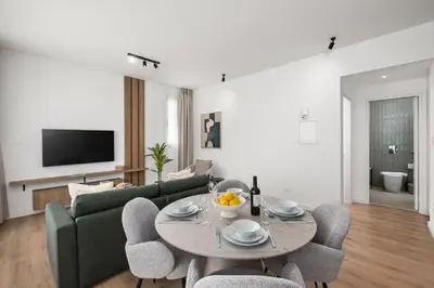 a living room with a couch and a table and chairs at Artemis 202 - Seaside Stories in Livadhia