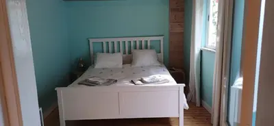 a bedroom with a white bed with a blue wall at Jay's Nest in Larnaka