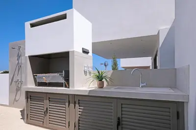 a white kitchen with a sink and a counter at Princess Anne Luxury Villa - Large Pool in Protaras