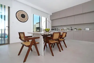 a kitchen with a table and chairs and a clock at Princess Zena Luxury Villa - Large Pool in Protaras