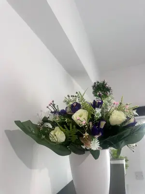 a white vase filled with a bouquet of flowers at Faneromeni 33 in Scala