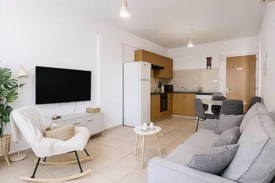 a living room with a couch and a tv at Fresh & Cozy-close to the beach in Paralimni