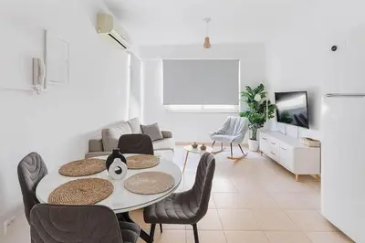 a white living room with a table and chairs at Fresh & Cozy-close to the beach in Paralimni