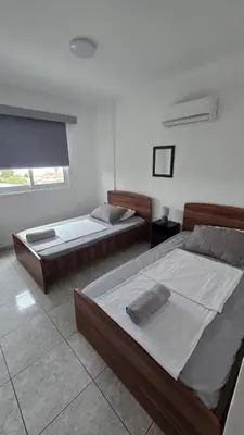 a bedroom with two beds and a window at ERIKA Sea Breeze Makenzie in Larnaka