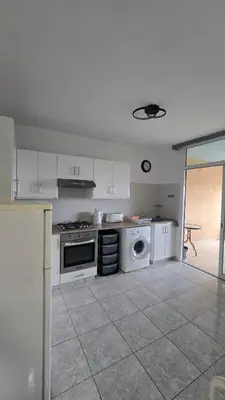 a kitchen with a stove and a washing machine at ERIKA Sea Breeze Makenzie in Larnaka