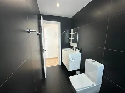 a bathroom with a toilet and a sink and a mirror at Premium City Center 10th Floor Sky View -Suite 103 in Nicosia