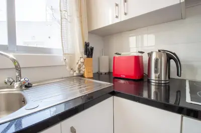 a kitchen with a sink and a red appliance at Sea View Stay 200m to Beach in Voroklini