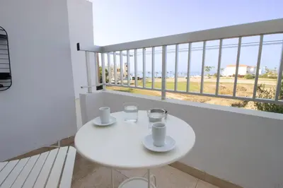 a white table with two cups and glasses on a balcony at Sea View Stay 200m to Beach in Voroklini