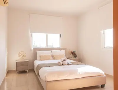 a bedroom with a bed with a teddy bear on it at TelMar Sunrise View 100m from the Sea in Larnaka