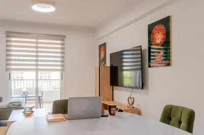a room with a table with a laptop and chairs at TelMar Sunrise View 100m from the Sea in Larnaka