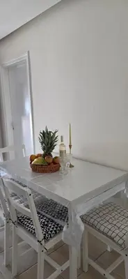 a white dining table with a bowl of fruit and a plant on it at CrisMari Napa in Ayia Napa