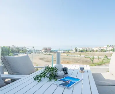 a table on a balcony with a view of the beach at TelMar Sea View - 2 min walk to the Beach in Voroklini