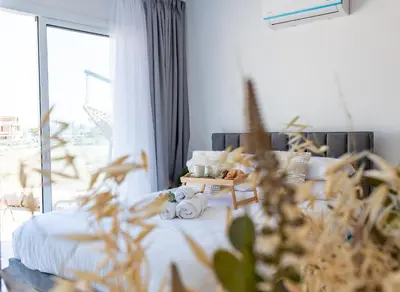 a living room with a bed and a large window at TelMar Sea View - 2 min walk to the Beach in Voroklini
