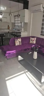 a purple couch in a living room with a table at Modern apartment in North Nicosia