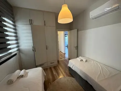 a small bedroom with two beds and a light at Caesar Resort Spa Long Beach