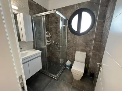 a bathroom with a shower and a toilet and a mirror at Caesar Resort Spa Long Beach