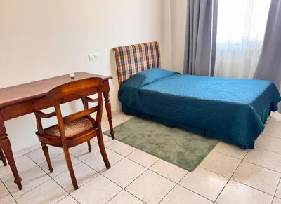 a bedroom with a desk and a bed and a chair at Family House in Limassol