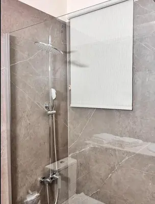 a shower with a glass door in a bathroom at Family House in Limassol