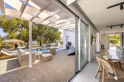 an open patio with a view of a pool at Protaras Leomi Seaview Villa in Protaras