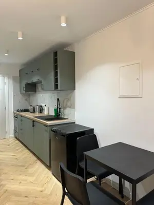 a kitchen with green cabinets and a table and chairs at Ayia Napa 1 Studio in Ayia Napa