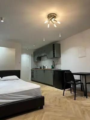 a bedroom with a bed and a table and a kitchen at Ayia Napa 1 Studio in Ayia Napa