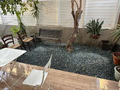a bench and chairs in a courtyard with a tree at Ayia Napa 1 Studio in Ayia Napa