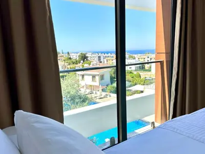 a bedroom with a bed and a view of the ocean at Bohemian penthouse in Girne Alsancak, close to Merit hotels in Kérynia