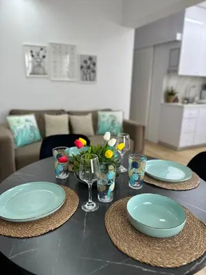 a table with plates and glasses and flowers on it at Trinity Getaway in Paralimni