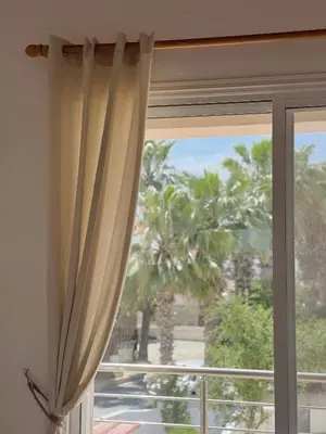 a window with a view of a palm tree at 5-Min Walk to Beach - Bright 2-BR Home with Private Garden & Sunset Views in Voroklini