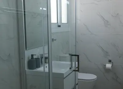 a white bathroom with a toilet and a glass shower at Limassol Sunbliss by Staycom in Limassol